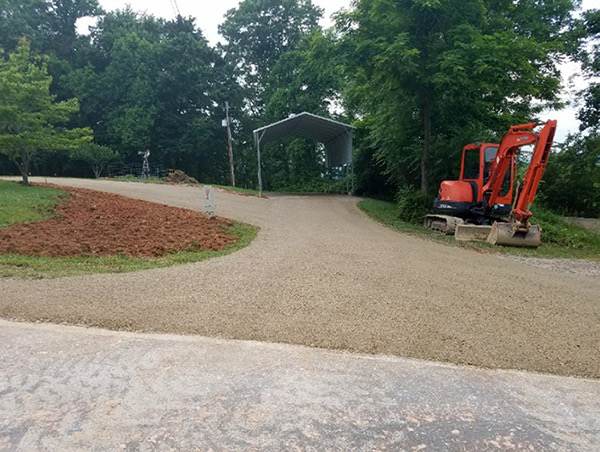 Mini excavator grading a new gravel driveway