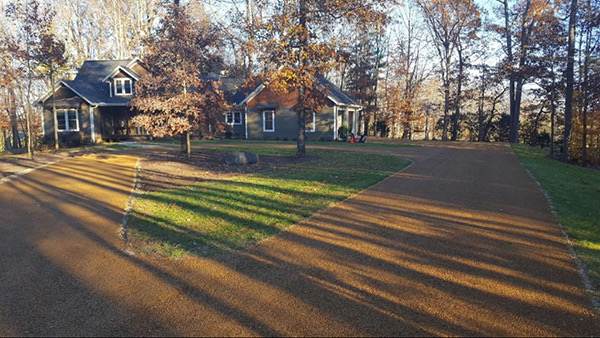 Surface-treated driveway leading to a home in autumn