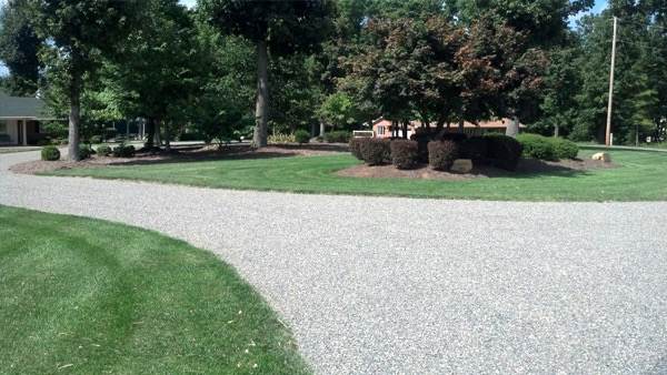 Tar and gravel driveway curving through a lawn