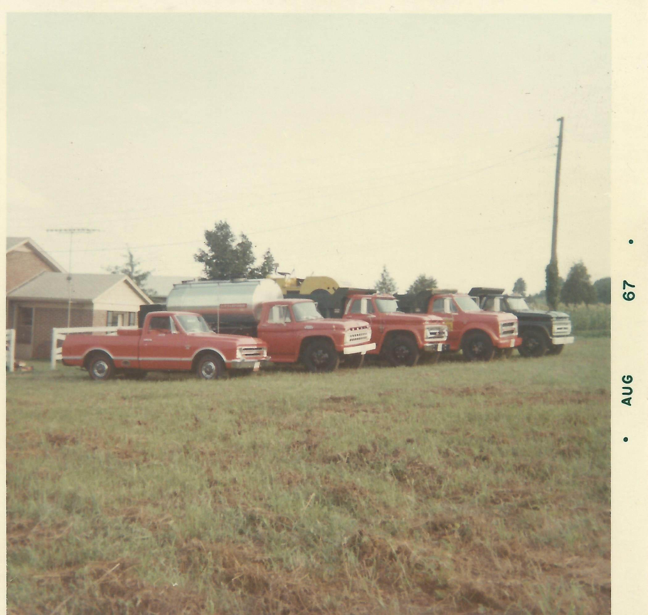Vintage photo of the family’s red work trucks